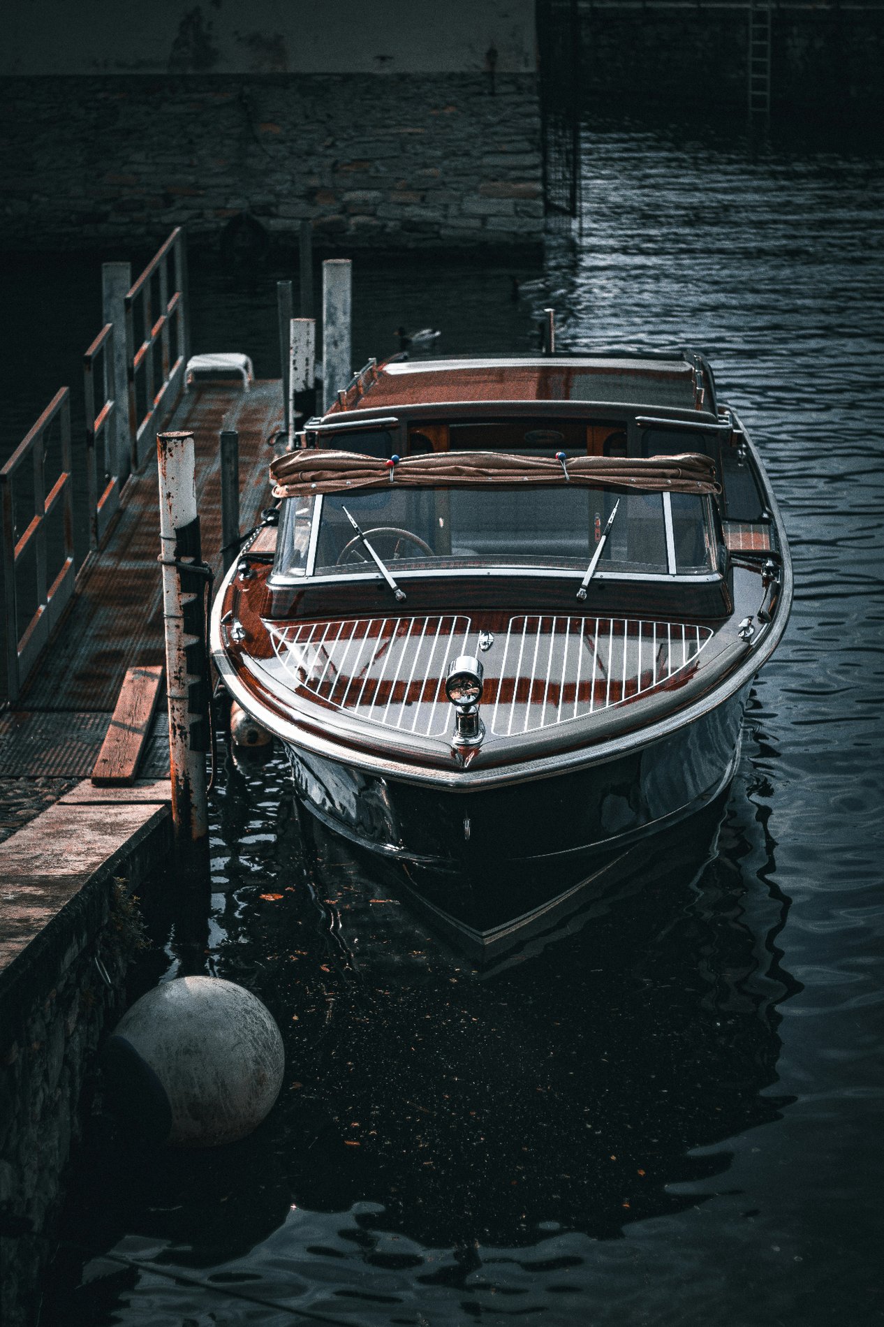 Barca classica in stile Riva attraccata a un molo sul Lago di Como