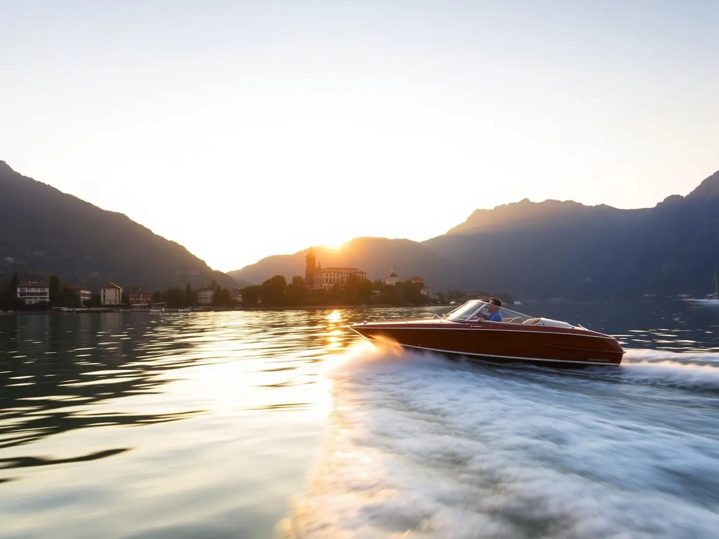 Motoscafo in legno in stile Riva che sfreccia sul lago davanti a Lecco